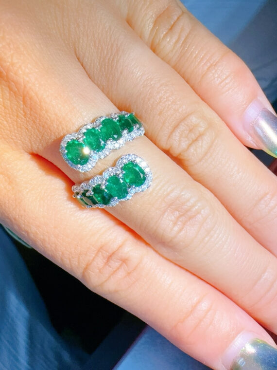 Anillo serpentino de esmeraldas con halo de diamantes